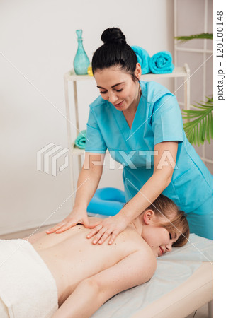 A woman is given a medical massage by a chiropractor A woman is given a medical massage by a chiropractor 120100148