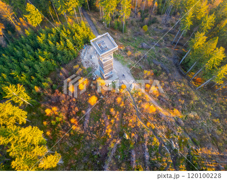 The Cisarsky Kamen wooden lookout tower stands tall among vibrant autumn foliage near Liberec as the sun sets, casting warm hues across the landscape and inviting exploration. The Cisarsky Kamen wooden lookout tower stands tall among vibrant autumn foliage near Liberec as the sun sets, casting warm hues across the landscape and inviting exploration. 120100228