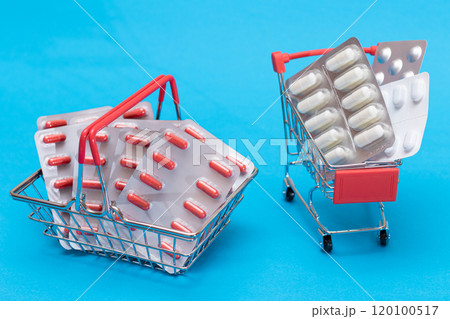 Pills and Capsules in Shopping Cart on Blue Background Pills and Capsules in Shopping Cart on Blue Background 120100517