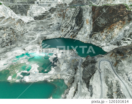 Large limestone quarry operation. Industrial trucks working at open pit mining site with striking turquoise water. Resource extraction process. Mining operation in limestone quarry. Industrial scale. 120101614