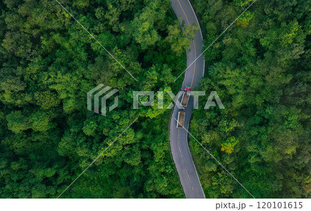 Aerial view of hydrogen energy truck driving on highway road in green forest. Sustainable transportation. Blue truck driving on asphalt road in forest. Hydrogen fuel cell vehicle. Zero emission car. 120101615