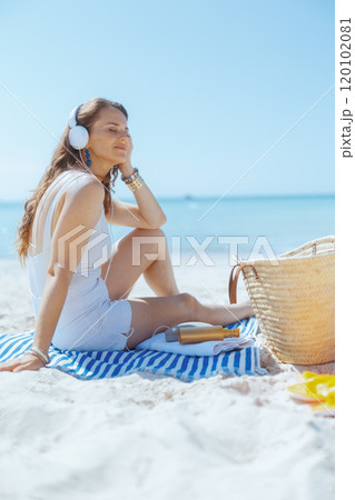 relaxed elegant woman on ocean coast listening to music relaxed elegant woman on ocean coast listening to music 120102081