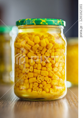 Canned sweet corn in jar on wooden table. Canned sweet corn in jar on wooden table. 120102101