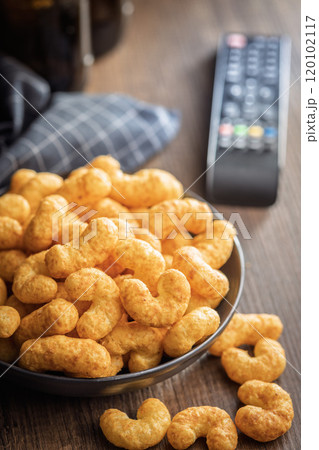 Puffed crispy Peanut flips on plate on wooden table. Puffed crispy Peanut flips on plate on wooden table. 120102117