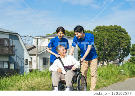 車椅子に乗ったシニア男性と会話する介護士 120102577