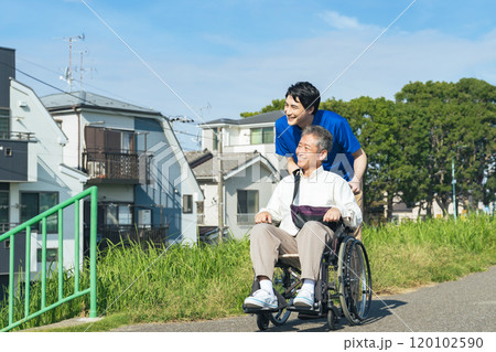 街を歩く車椅子に乗ったシニア男性と介護士 街を歩く車椅子に乗ったシニア男性と介護士 120102590