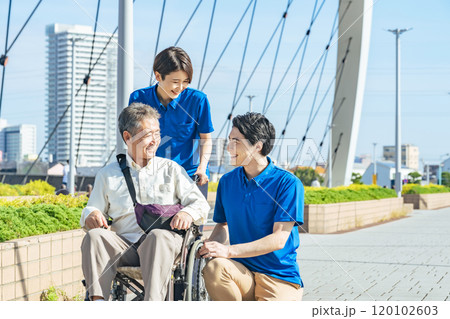車椅子に乗ったシニア男性と会話する介護士 120102603
