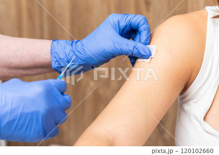 Medical assistant in gloves preparing patients arm for vaccination Medical assistant in gloves preparing patients arm for vaccination 120102660