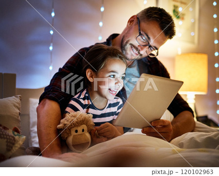 She loves story time with daddy. Cropped shot of a father reading his young daughter a bedtime story on a tablet. 120102963