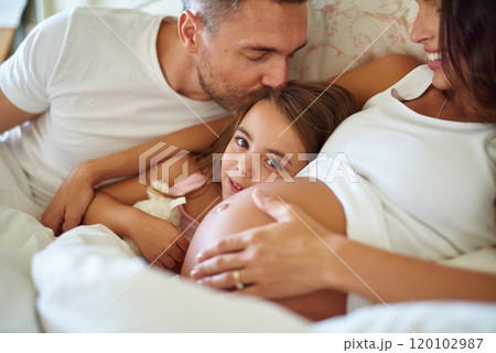 And soon there will be four. Shot of a happy little girl lying in bed with her dad and pregnant mother. 120102987