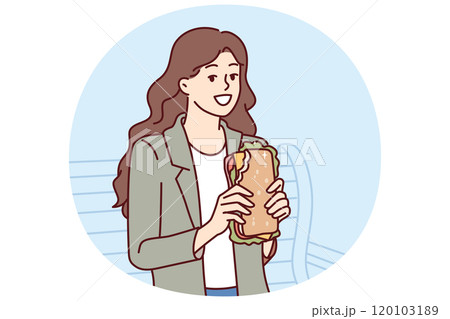Woman eats sandwich while sitting on bench in park and enjoying street food and good weather 120103189