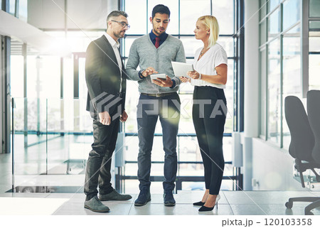 They make good ideas better. Shot of a group of coworkers talking together over a digital tablet in an office. 120103358