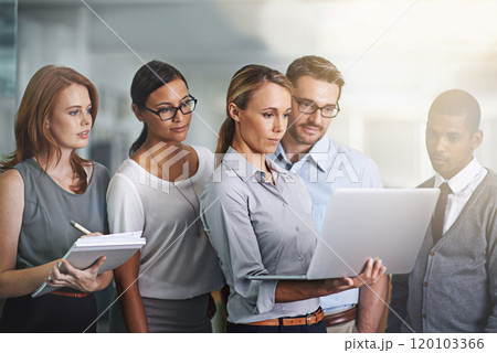 Collaboration is the key to success. Shot of a business team working on a laptop together. 120103366