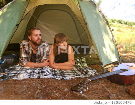 Into the woods. Shot of a young couple lying in a tent looking outwards. 120103470