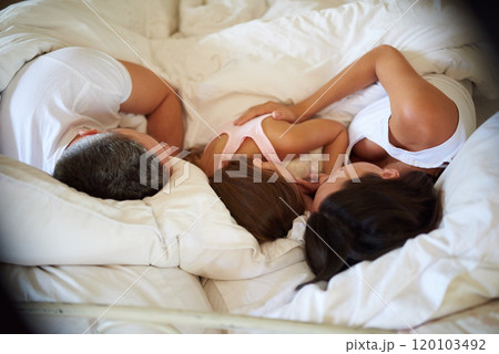 Family snuggle time. Shot of a family sleeping in bed at home. 120103492