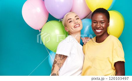 Celebrate the special women in your life. Studio shot of two young women holding a bunch of colourful balloons against a turquoise background. 120103497