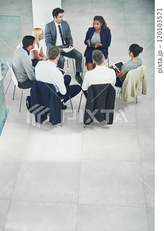 Formulating buisness plans. High angle shot of a group of coworkers talking together while sitting in a circle in an office. Formulating buisness plans. High angle shot of a group of coworkers talking together while sitting in a circle in an office. 120103571