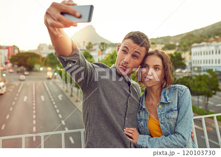 Lets get weird. Shot of a happy young couple taking a selfie together in the city. 120103730