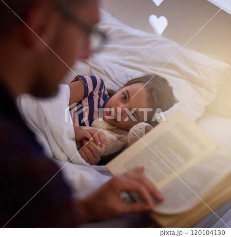 Preparing her to sleep. Shot of a father reading a bedtime story to his daughter. 120104130