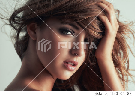 Sultry is the word. Studio portrait of a gorgeous young woman posing against a grey background. 120104188