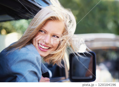 Feeling breezy. A young woman feeling the breeze in her hair through an open car window. Feeling breezy. A young woman feeling the breeze in her hair through an open car window. 120104196