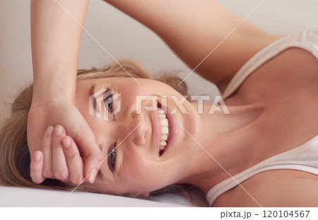 Start your day with a smile. Portrait of a beautiful young woman lying on her bed. Start your day with a smile. Portrait of a beautiful young woman lying on her bed. 120104567