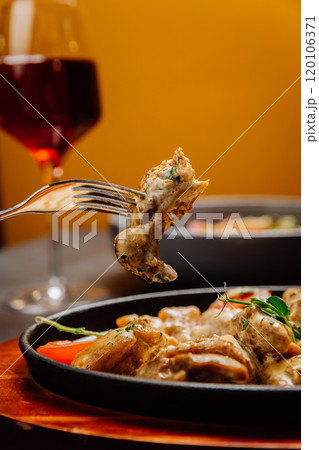 Gourmet creamy chicken in sauce with herbs, enjoyed with red wine for perfect fine dining experience 120106371