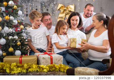 Family with children holding gifts in christmas interior 120107996