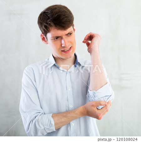 Young guy holding on to sore elbow 120108024