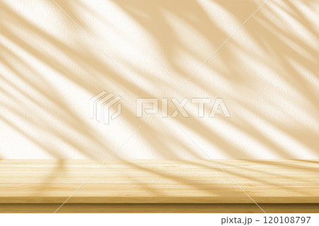 Empty wood table top on beige wall texture with tree leaves shadow background Empty wood table top on beige wall texture with tree leaves shadow background 120108797