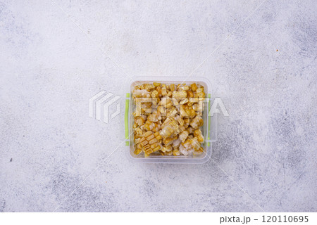 Frozen corn in plastic container 120110695