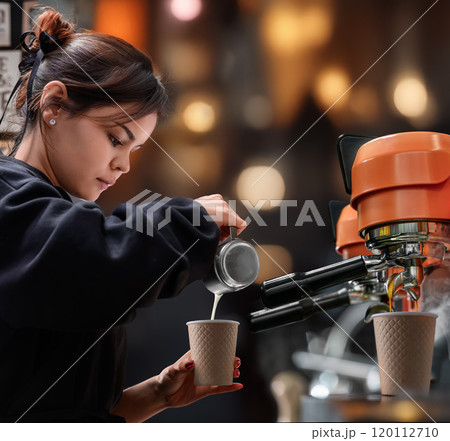 Female Barista Elegantly Pouring Beautiful Latte Art in a Warm and Cozy Cafe shop 120112710