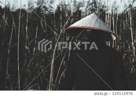 A mysterious samurai with a black mask and a conical hat stands in a bamboo forest, creating a mysterious and mesmerizing scene. The handsome samurai warrior conveys strength and power. 120112976