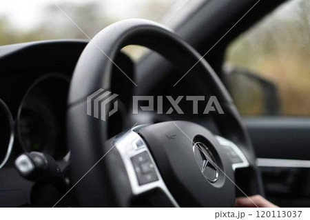 車の運転席のハンドルを握る手 120113037