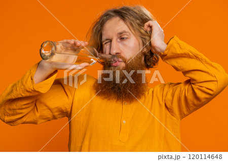 Drunk Caucasian man after party drinks vodka beverage from bottle, celebrating victory win addiction 120114648