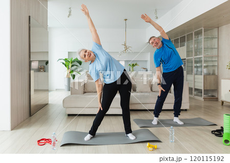 Fitness training. Senior mature healthy fit couple doing sports exercise at home. Mid age husband wife have training workout. Health care healthy lifestyle. Workout rehabilitation for old man woman 120115192