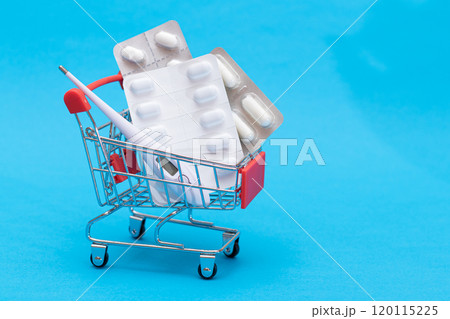 Pills and Capsules in Shopping Cart on Blue Background Pills and Capsules in Shopping Cart on Blue Background 120115225