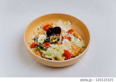Fresh Caesar salad with crispy chicken, boiled egg, cherry tomatoes, parmesan, and edible flower 120115325