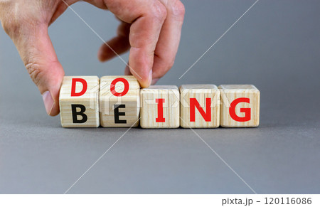 Doing or being symbol. Concept word Doing and Being on wooden cubes. Businessman hand. Beautiful grey table grey background. Business doing or being concept. Copy space. Doing or being symbol. Concept word Doing and Being on wooden cubes. Businessman hand. Beautiful grey table grey background. Business doing or being concept. Copy space. 120116086
