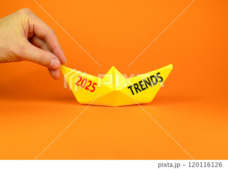 Planning 2025 trends new year symbol. Concept words 2025 Trends on beautiful yellow paper boat. Beautiful orange paper background. Businessmen hand. Business 2025 trends new year concept. Copy space. 120116126