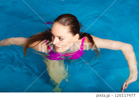 woman enjoying the water in swimming pool 120117477
