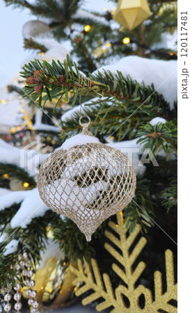 Branches of Christmas tree with beautiful decorations covered with snow 120117481