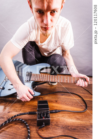 Man setting up guitar equipment 120117608
