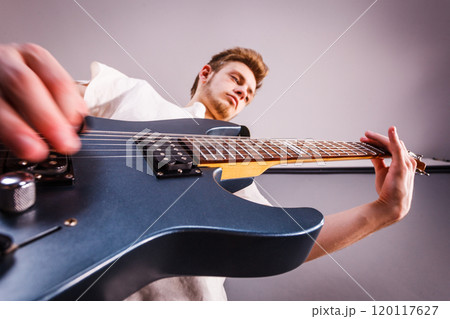 Young man is playing electric guitar Young man is playing electric guitar 120117627