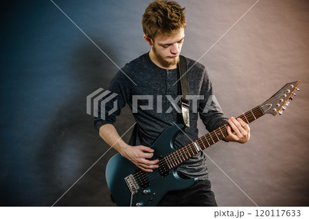 Young man playing electric guitar 120117633
