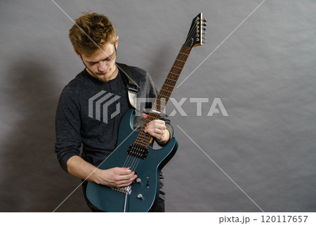 Young man playing electric guitar 120117657
