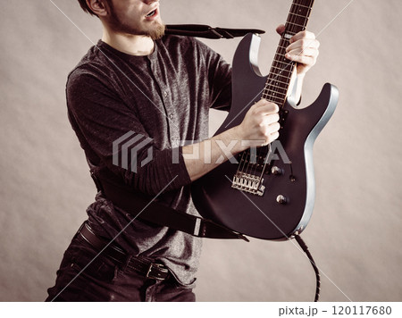 Young man playing electric guitar 120117680