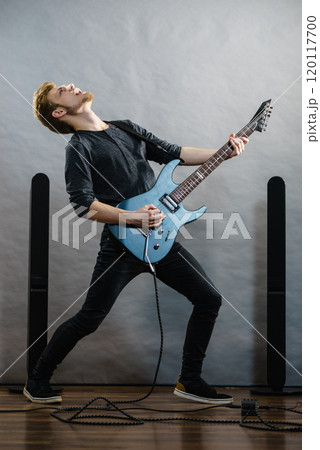 Young man playing electric guitar 120117700