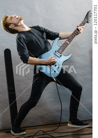 Young man playing electric guitar 120117701