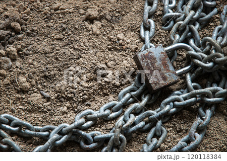 An old metal chain lies on the ground An old metal chain lies on the ground 120118384